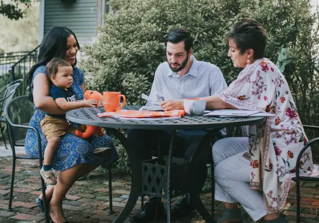 A family sitting with a real estate agent looking over information.